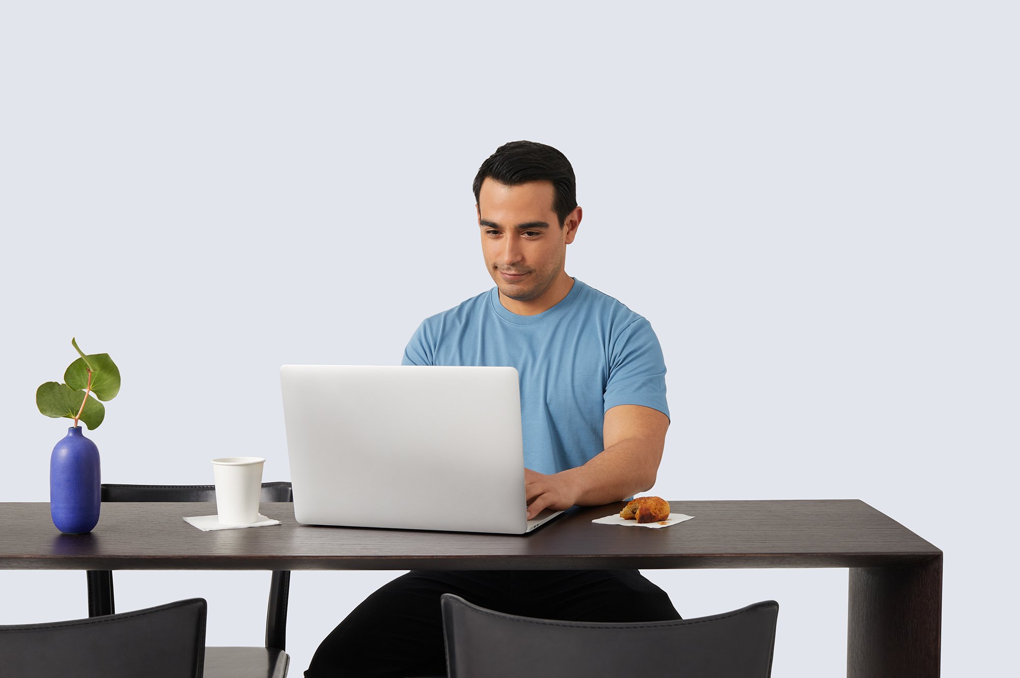 A man sitting at a desk using a laptop