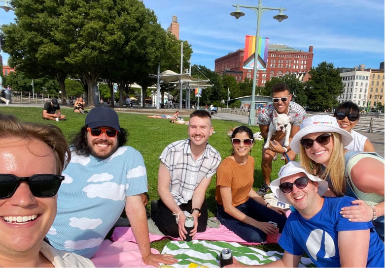 Betterment employees sitting outside at a Pride picnic.