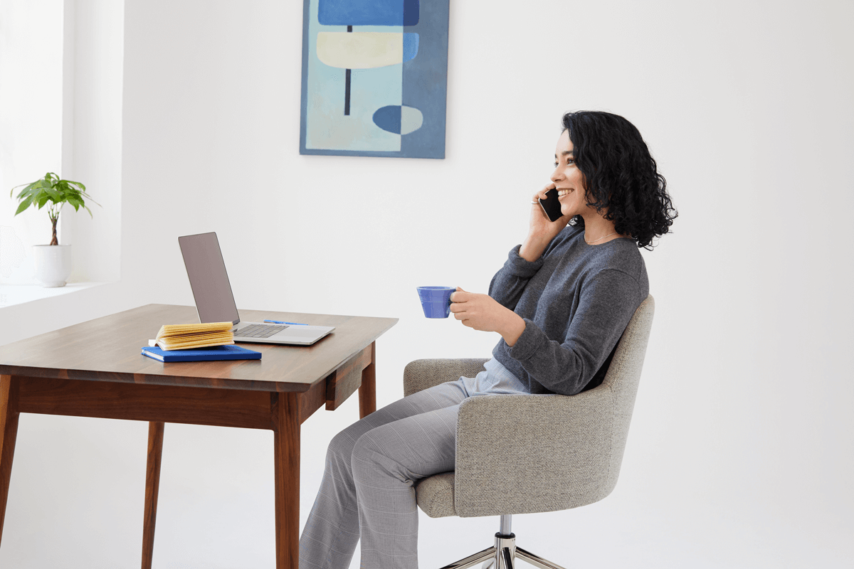 Woman sitting at a desk talking on the phone.