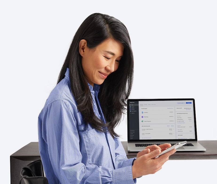 Woman sitting, looking down at her phone.